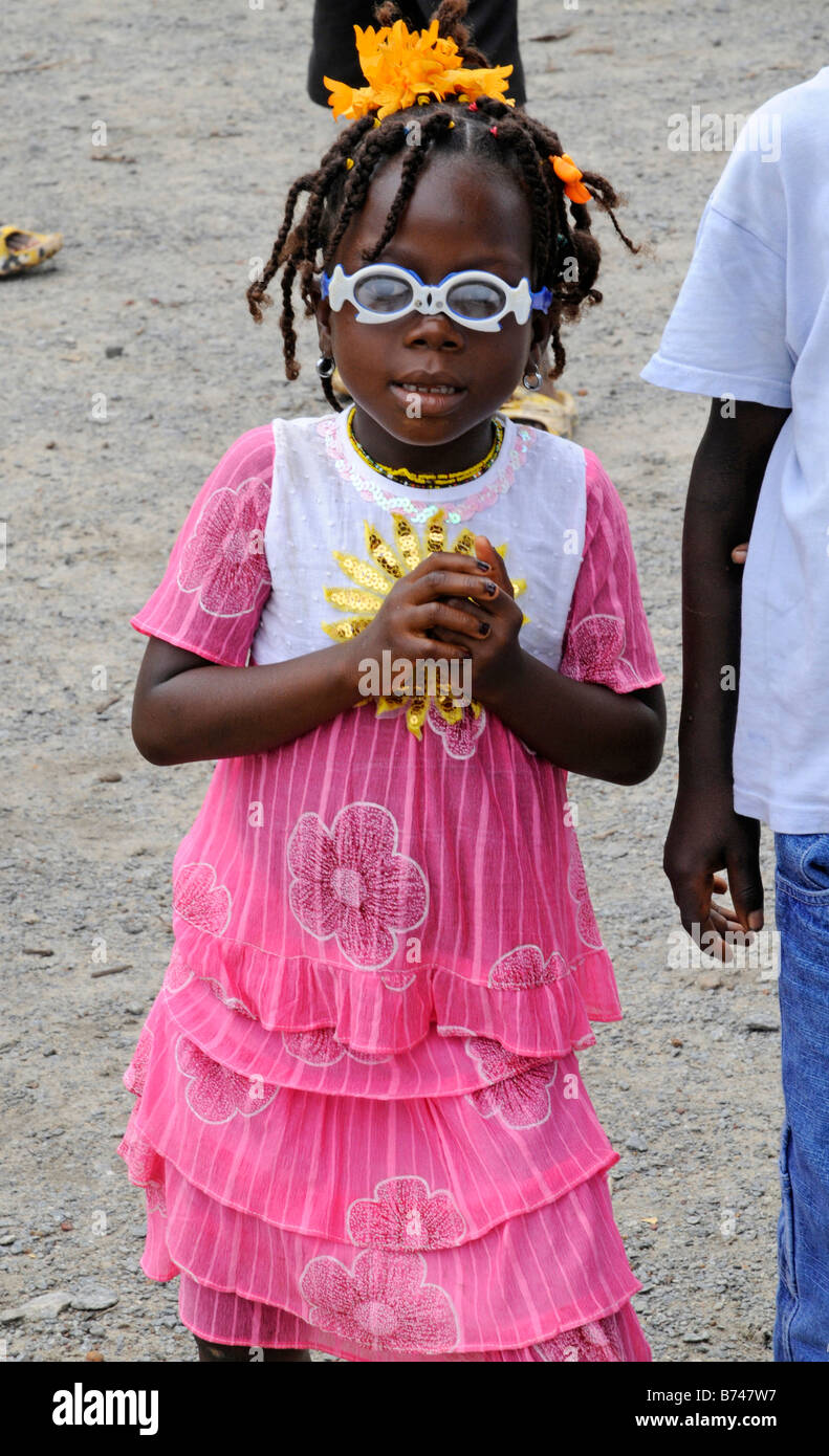 Jeune fille libérienne en robe rose et lunettes de soleil en plastique jouet le jour de l'indépendance Banque D'Images