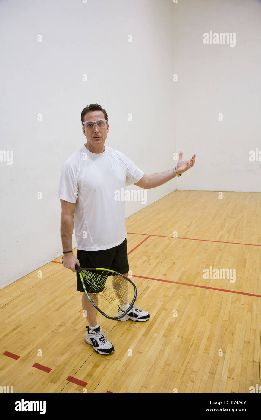 Homme d'âge moyen jouant dans une piscine de racquetball Banque D'Images