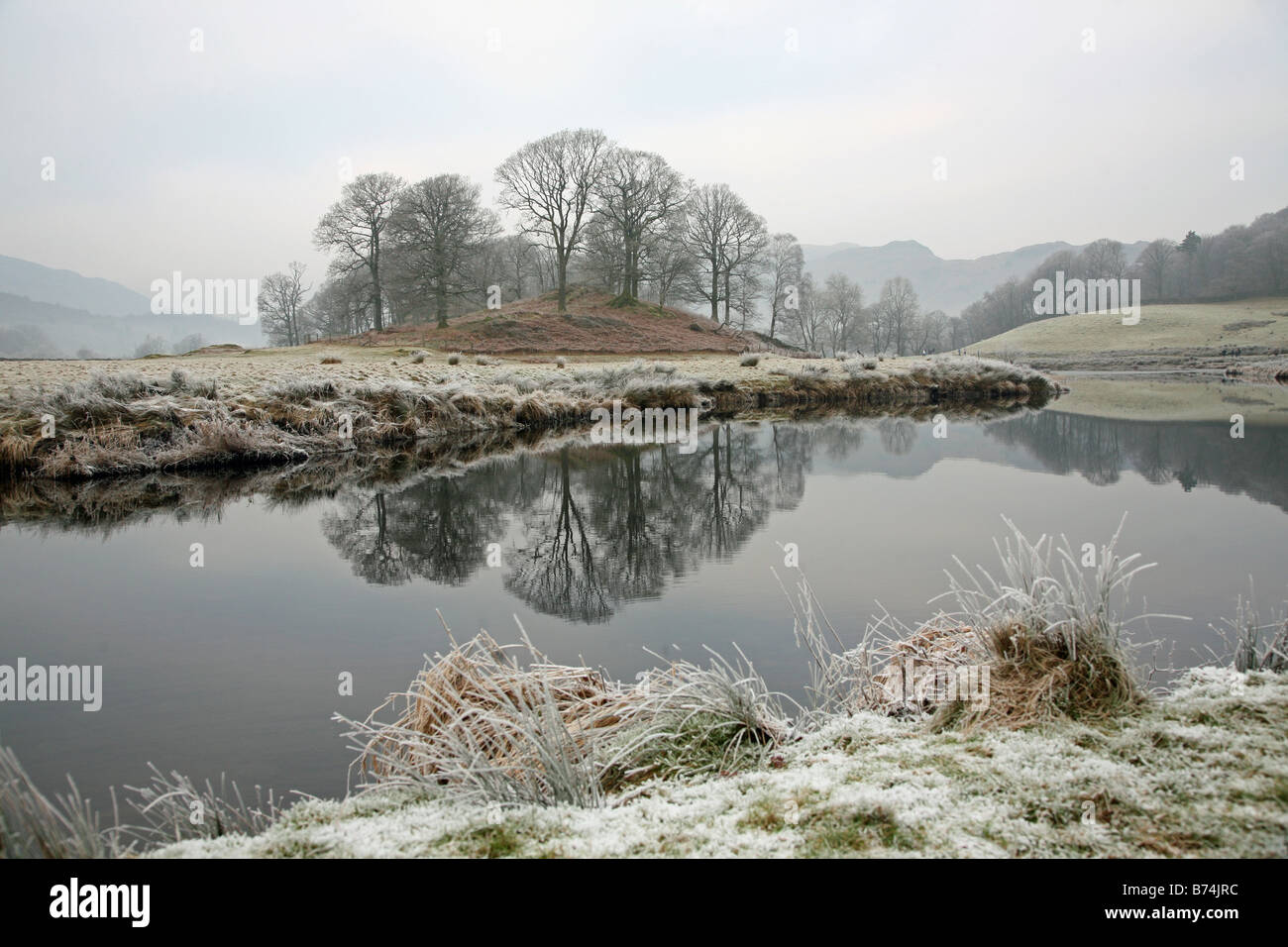 L'hiver dans la région du Lake District, avec le gel et arbres se reflétant dans l'eau Banque D'Images