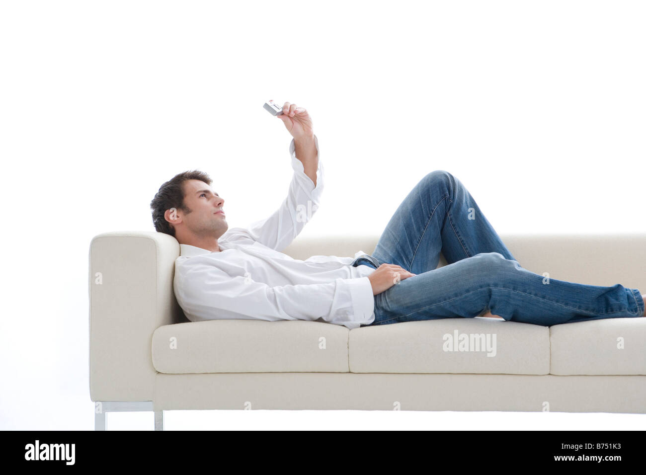 L'un mid adult man lying on sofa photographing lui-même avec l'appareil photo Banque D'Images