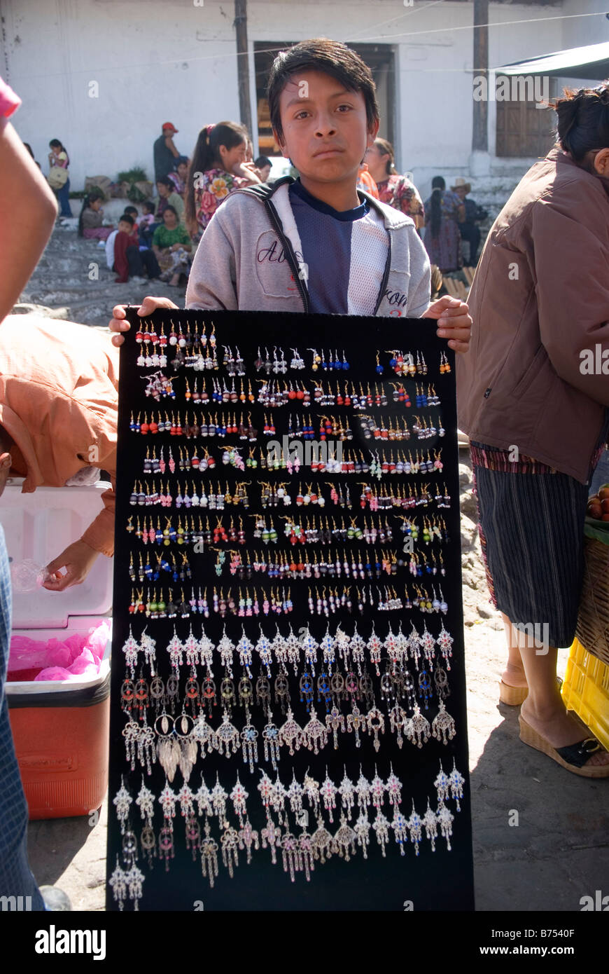 Jeune garçon fait main vente boucles d sur le marché de Chichicastenango, Guatemala. Banque D'Images