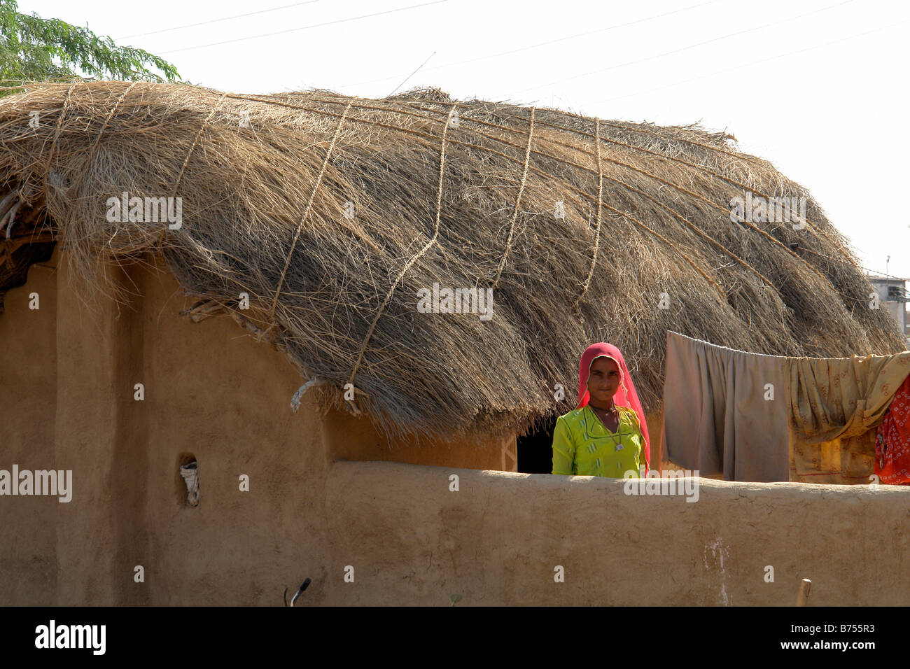 Village indien femme avec toit de chaume traditionnel chambre au Rajasthan Banque D'Images