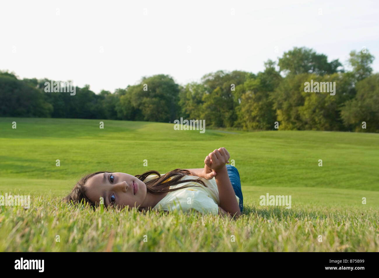 Fillette de huit ans portant sur l'herbe en Park, Winnipeg, Canada Banque D'Images