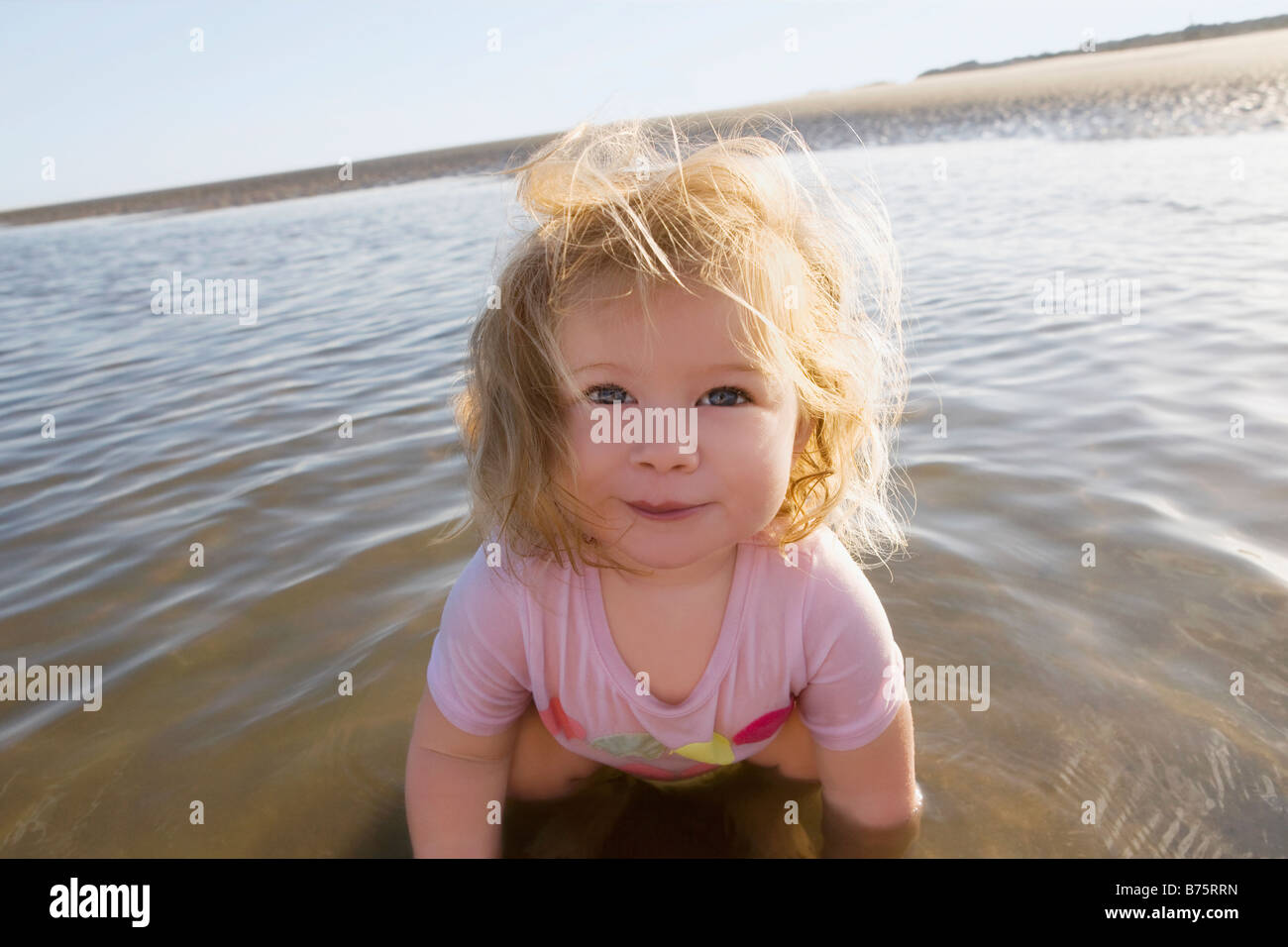 Portrait d'une petite fille jouant avec de l'eau et souriant Banque D'Images