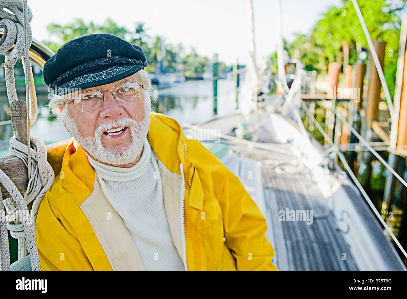 Portrait of a senior man leaning against a wooden post Banque D'Images