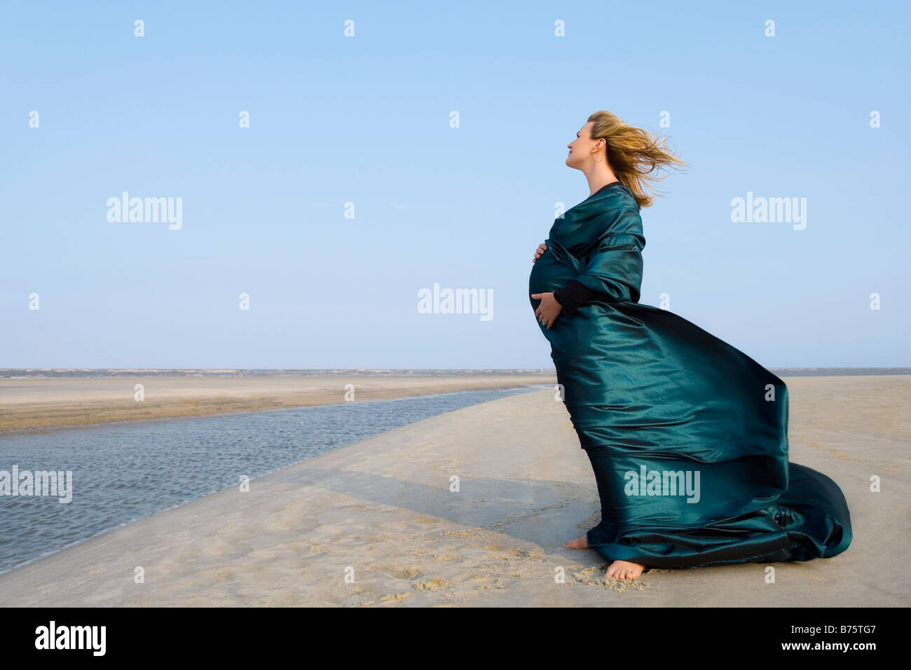 Portrait d'une femme enceinte debout sur la plage Banque D'Images