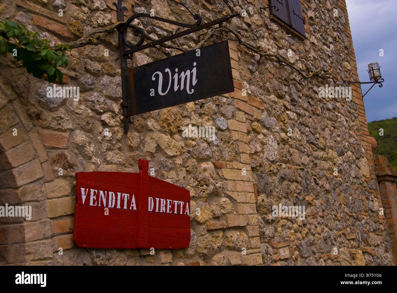Une pierre et brique store front en Toscane, Italie sur une vigne, où ils vendent du vin à l'ancienne, meubles anciens signes. Banque D'Images