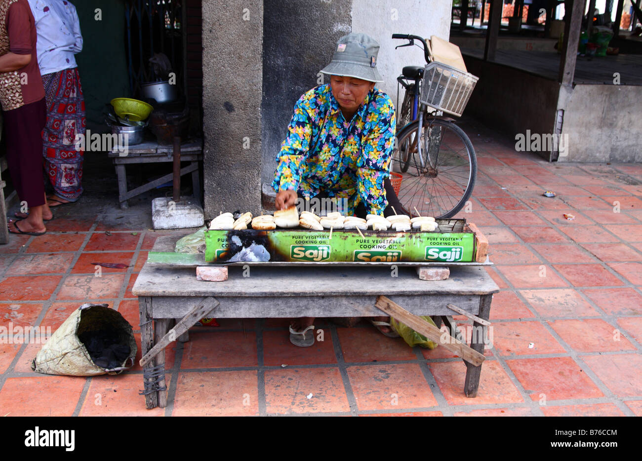 Femme vendant Banane grillée dans la rue de Kampot, Cambodge Banque D'Images