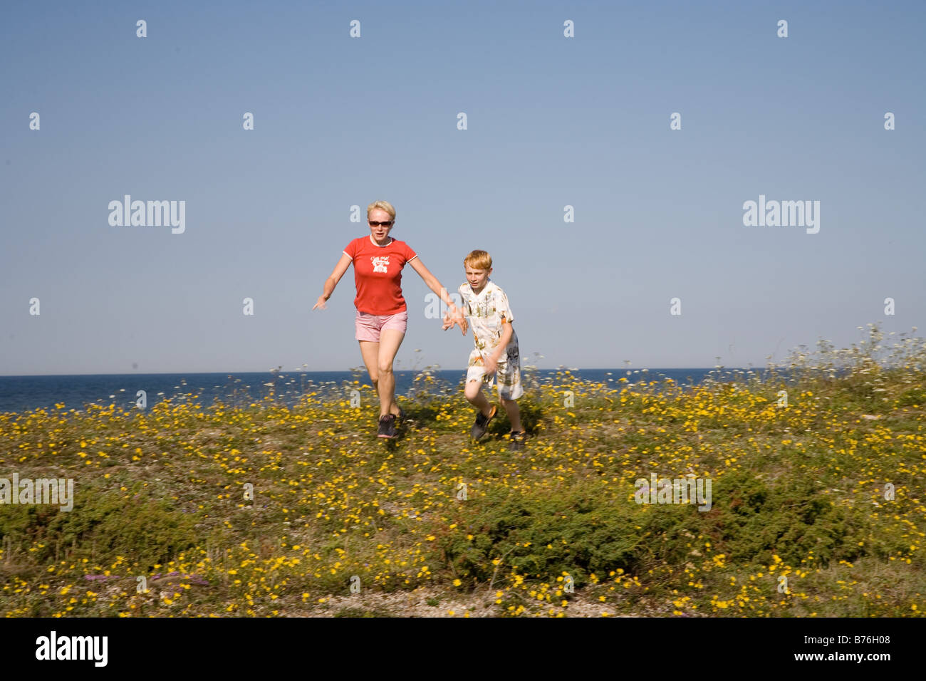Mère et Fils en marche main dans la main, île de Saaremaa, l'Estonie, Europe Banque D'Images