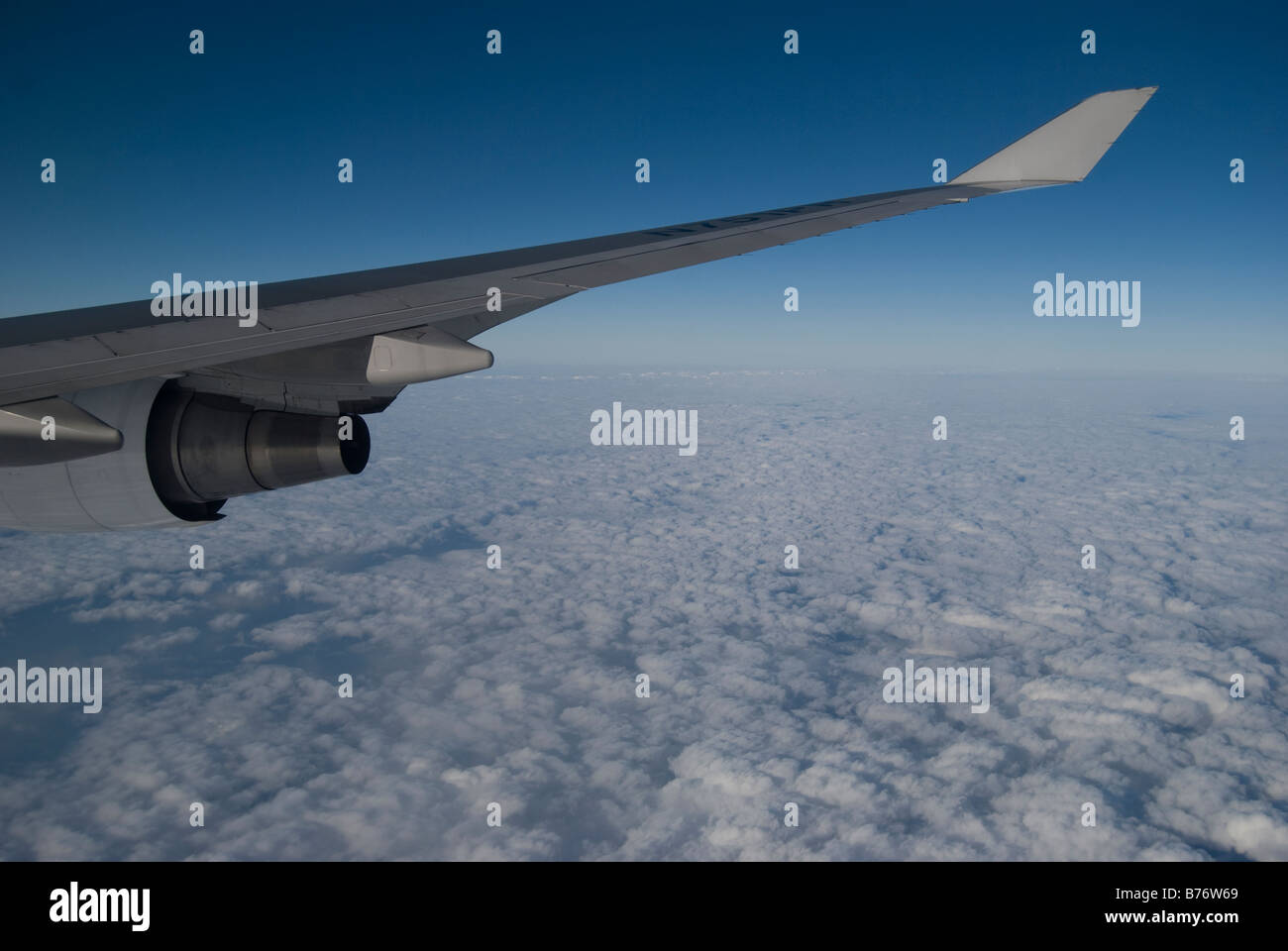 Voir des nuages et de l'aile à travers la vitre d'Air Philippines Boeing 747 jumbo jet Banque D'Images