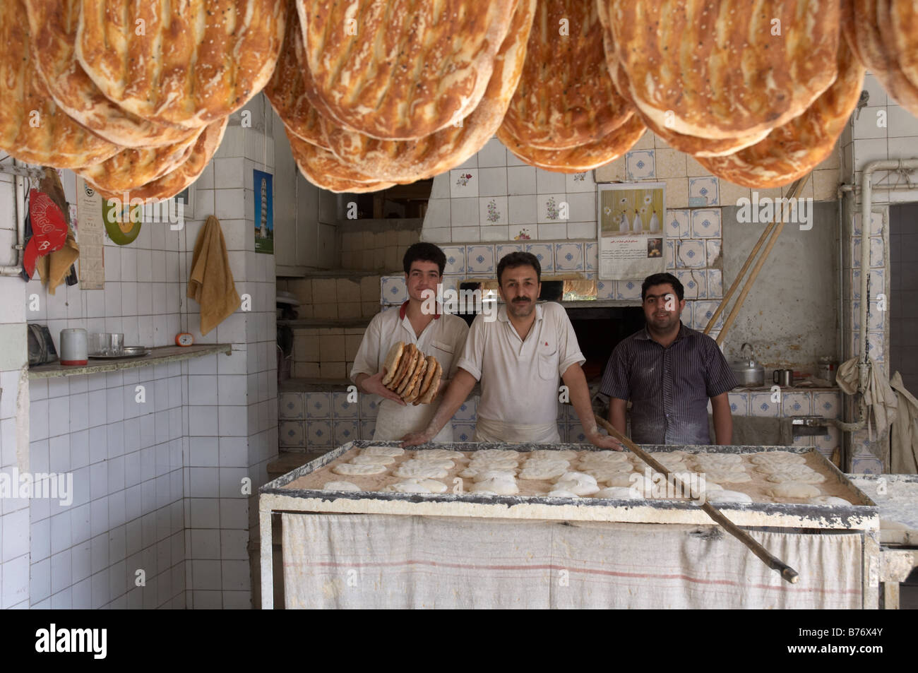 Trois boulangers posant pour l'appareil photo pendant le travail dans une boulangerie Barbari situé dans le centre-ville de Nazi Abad, Téhéran Banque D'Images