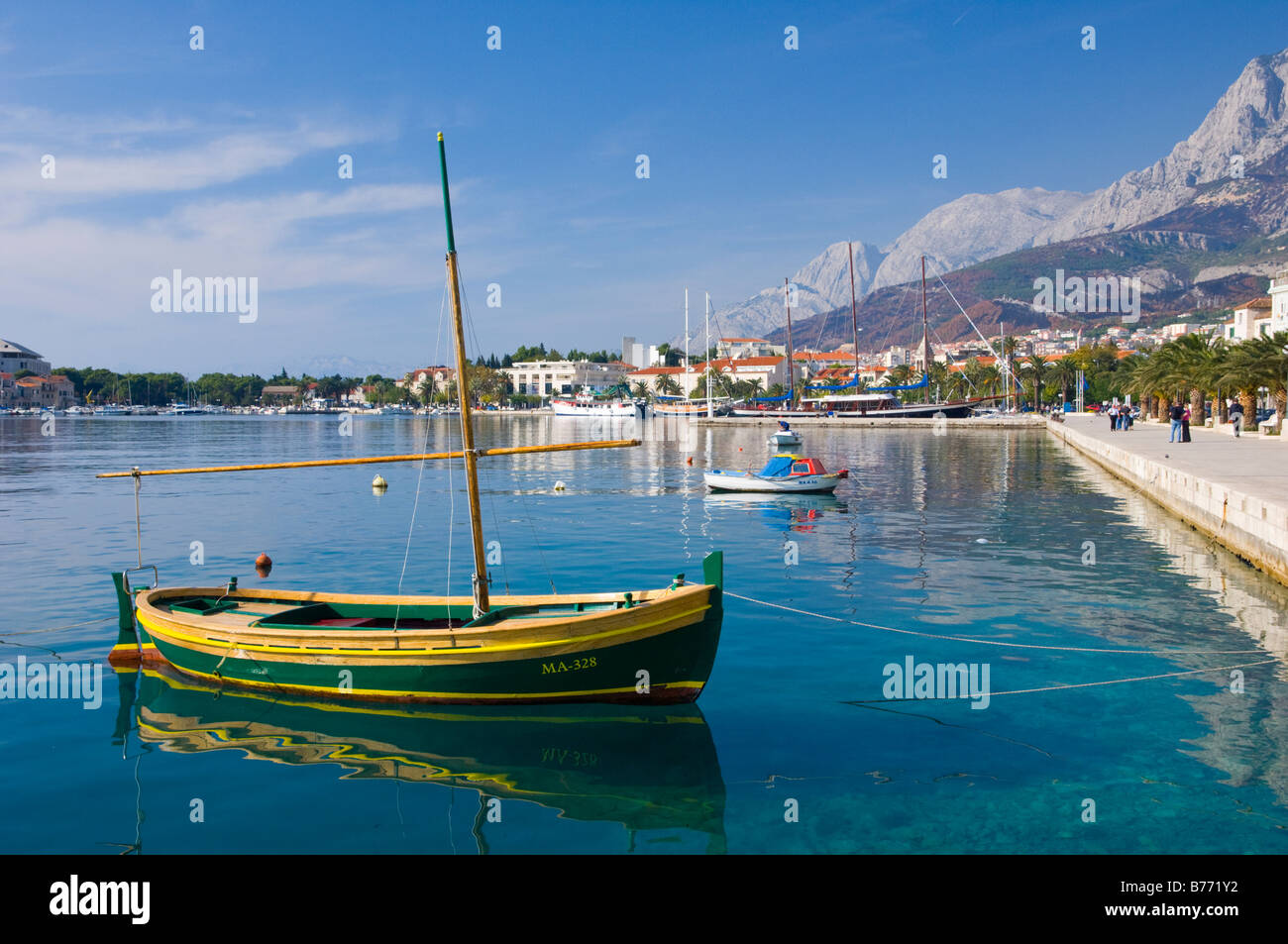 Le port avec une marche au bord de l'eau et des bateaux de pêche dans la région de Makarska Croatie Banque D'Images