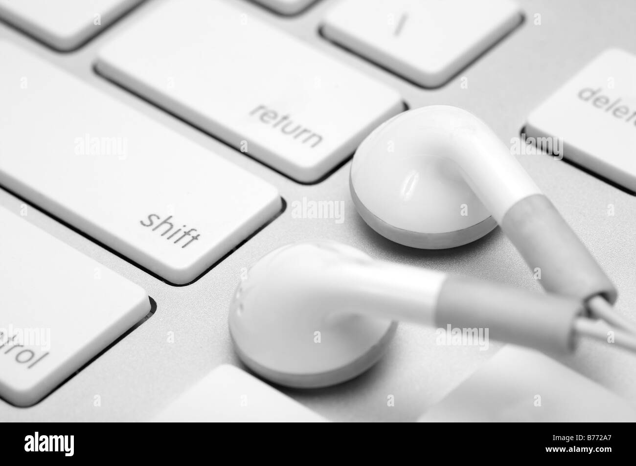Close up d'un écouteur sur un clavier blanc Banque D'Images