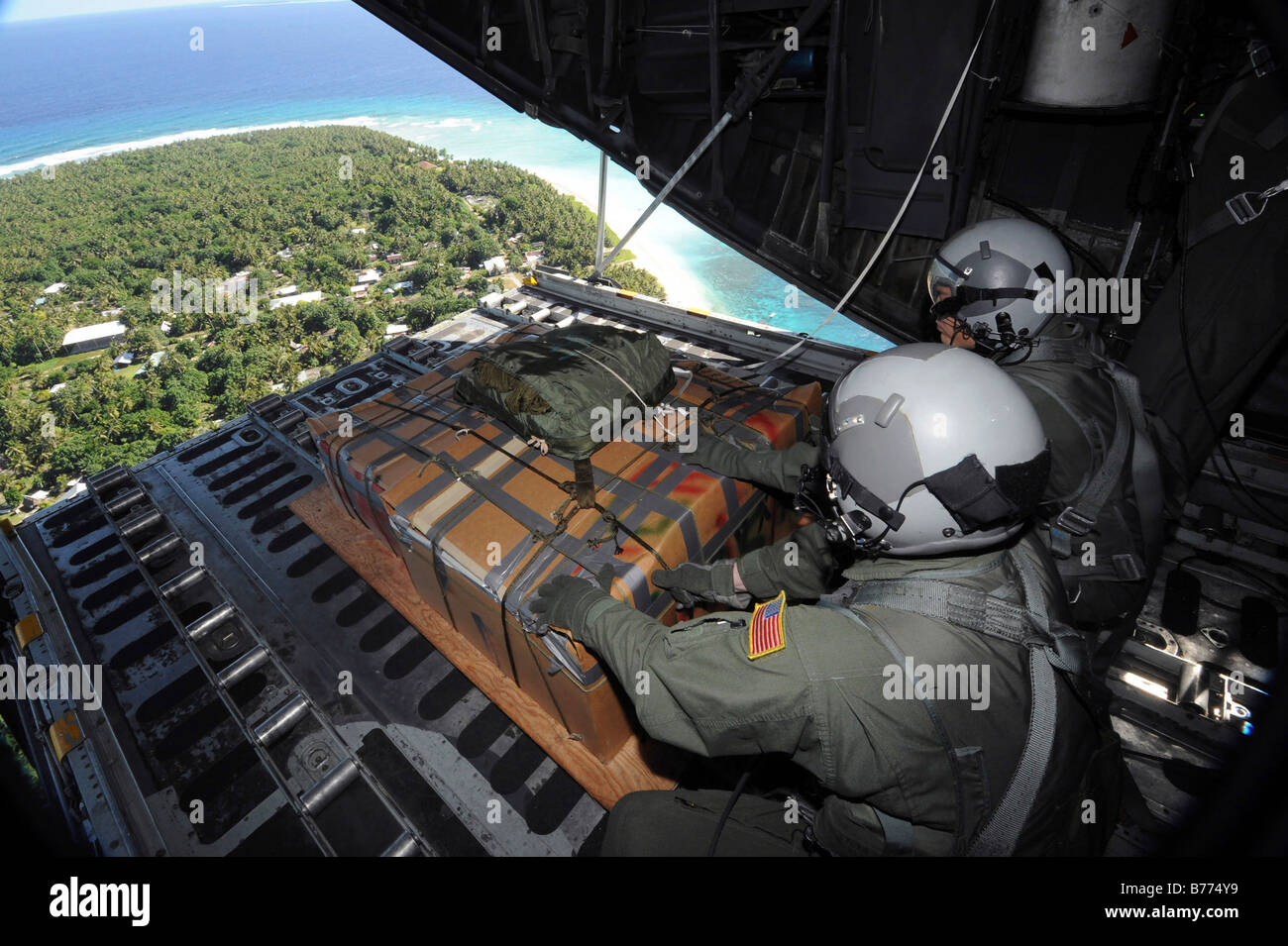 Aviateurs pousser une palette des dons de marchandises sur l'île de Yap à partir d'un C-130 Hercules. Banque D'Images