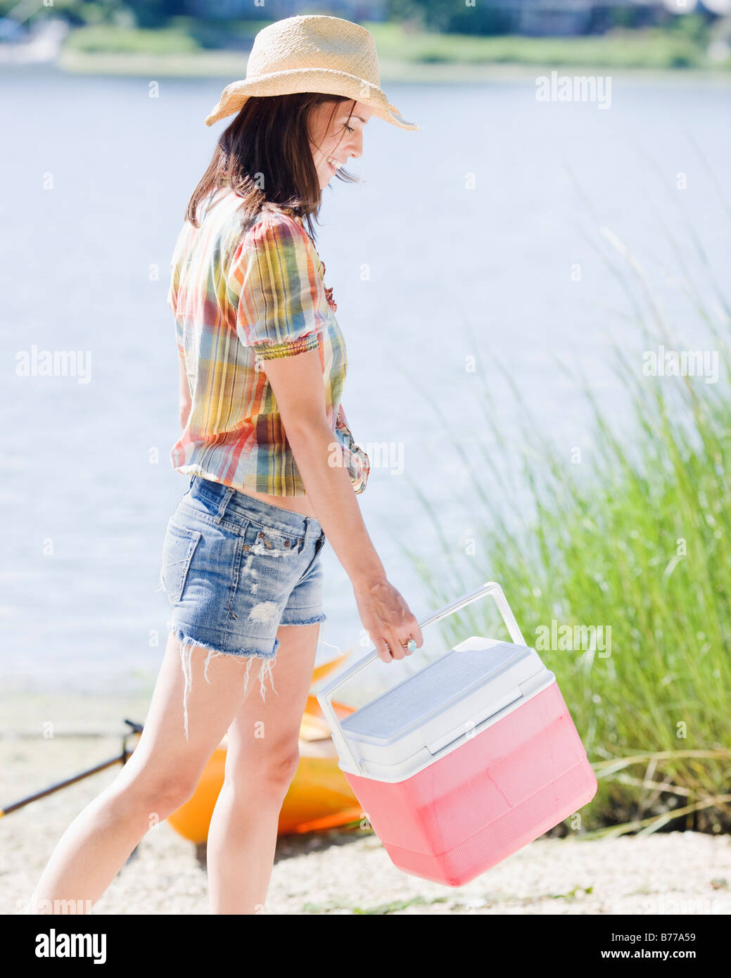 Femme transportant poitrine de la glace sur la plage Banque D'Images