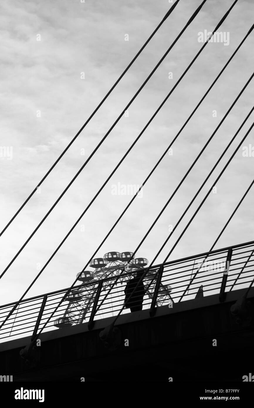 London Eye silhouetté contre piétons tout en marchant sur la passerelle du Jubilé, Londres Banque D'Images