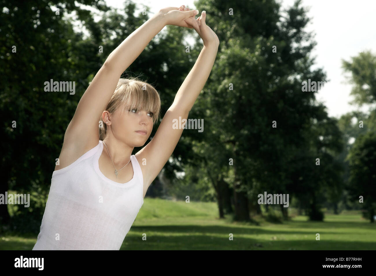 Jeune, blond foncé woman stretching Banque D'Images