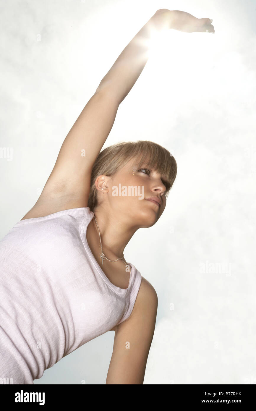 Jeune, blond foncé woman stretching Banque D'Images