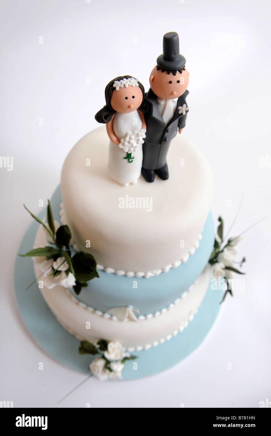Un gâteau de mariage avec fleurs décoratives et comique MARIÉS CHIFFRES Banque D'Images