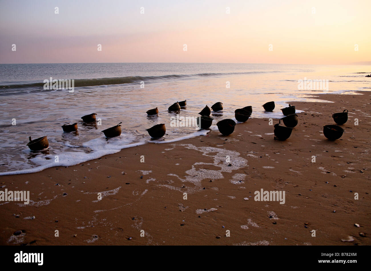 Coucher de soleil sur American d jour M1 casques de guerre sur le rivage d'Omaha Beach, Normandie, France Banque D'Images
