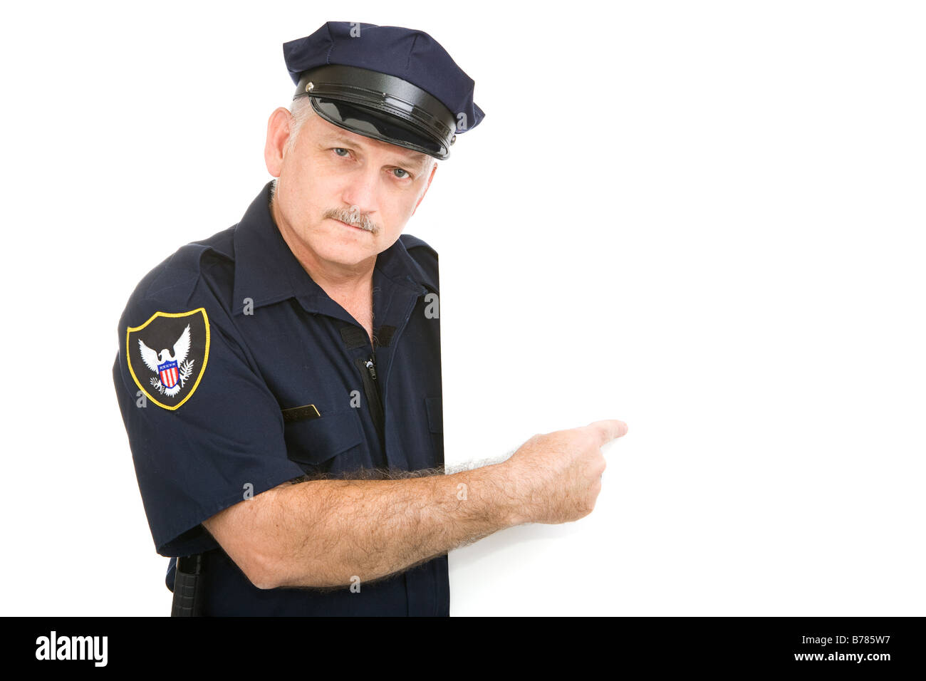 Serious mature policier pointant à l'espace blanc vierge Insérez votre signe Banque D'Images