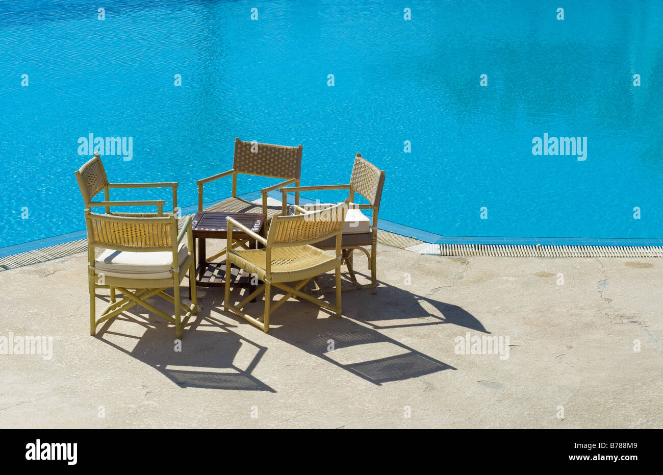 Table et chaises sur le bord de la piscine Banque D'Images