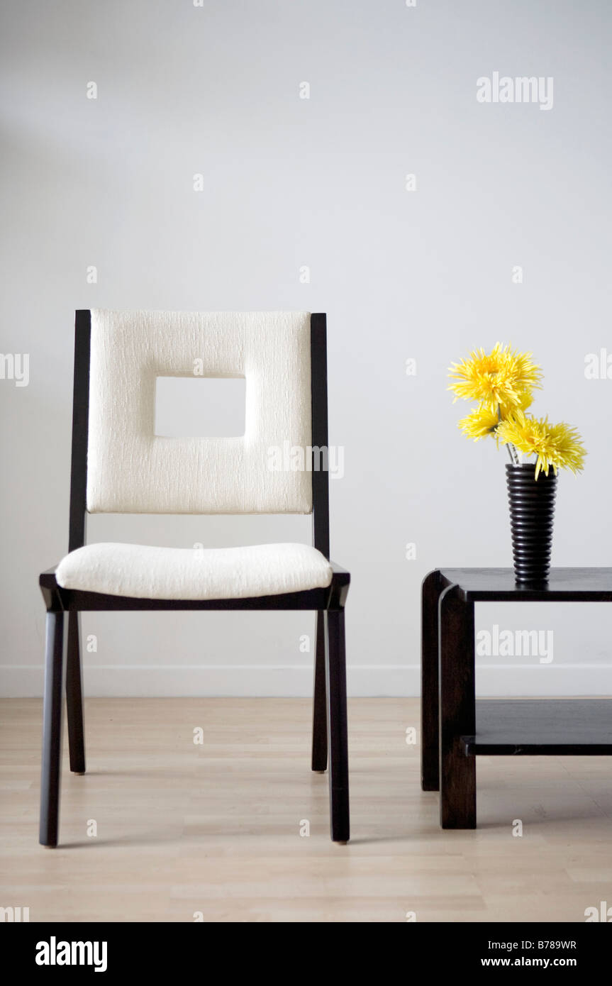 Chaise blanche dans cette chambre moderne avec des fleurs jaunes Banque D'Images