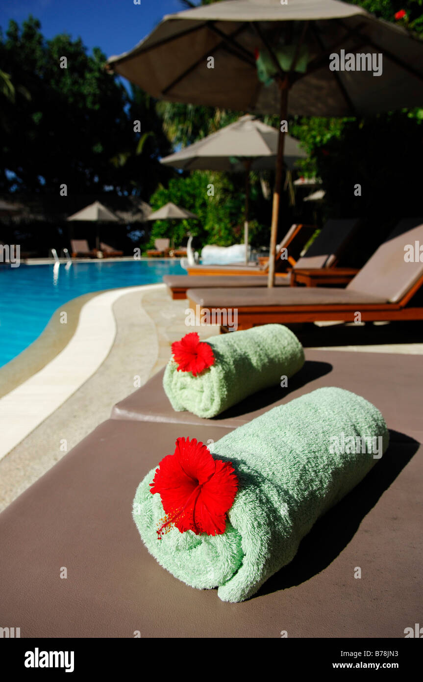 Serviettes roulées avec des parures de fleurs, Full Moon Resort, les Maldives, l'Océan Indien Banque D'Images