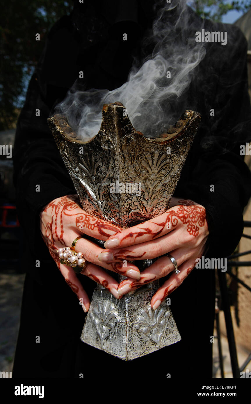 Mains d'une femme avec la peinture au henné holding porte encense, Dubaï, Émirats arabes unis, Moyen Orient Banque D'Images