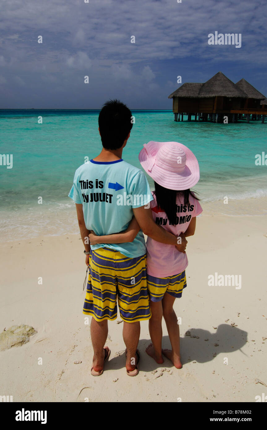 Les jeunes mariés japonais sur la plage le port de Romeo et Juliette T-shirts à Baros Resort, Maldives, océan Indien Banque D'Images