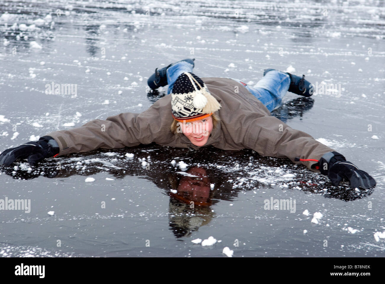 Les jeunes de sexe masculin (16-17) en hiver les vêtements qui traînent sur le lac gelé, smiling Banque D'Images