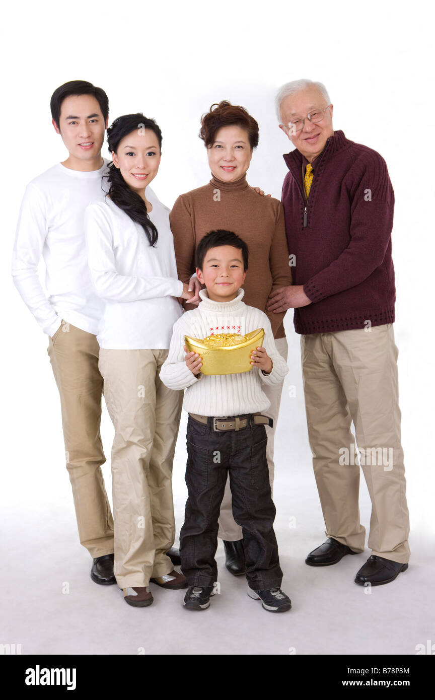 Les membres de la famille titulaires d'un grand lingot d'or et smiling at the camera Banque D'Images