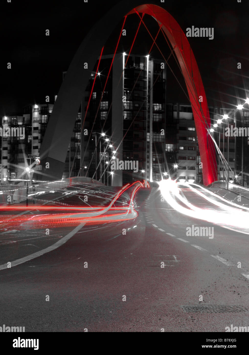 Photographie en noir et blanc avec couleur rouge de Clyde Arc sur la rivière Clyde et passant par voiture à Glasgow, Scotlan Banque D'Images