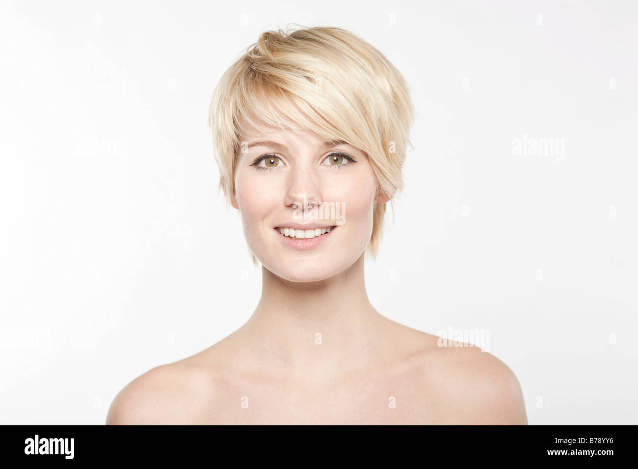 Jeune femme blonde aux cheveux courts en souriant à la caméra, de façon conviviale Banque D'Images