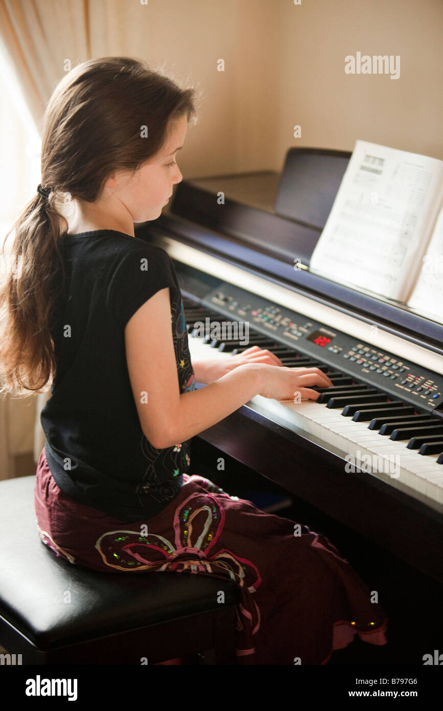 Jeune fille jouant un clavier de piano électronique Banque D'Images