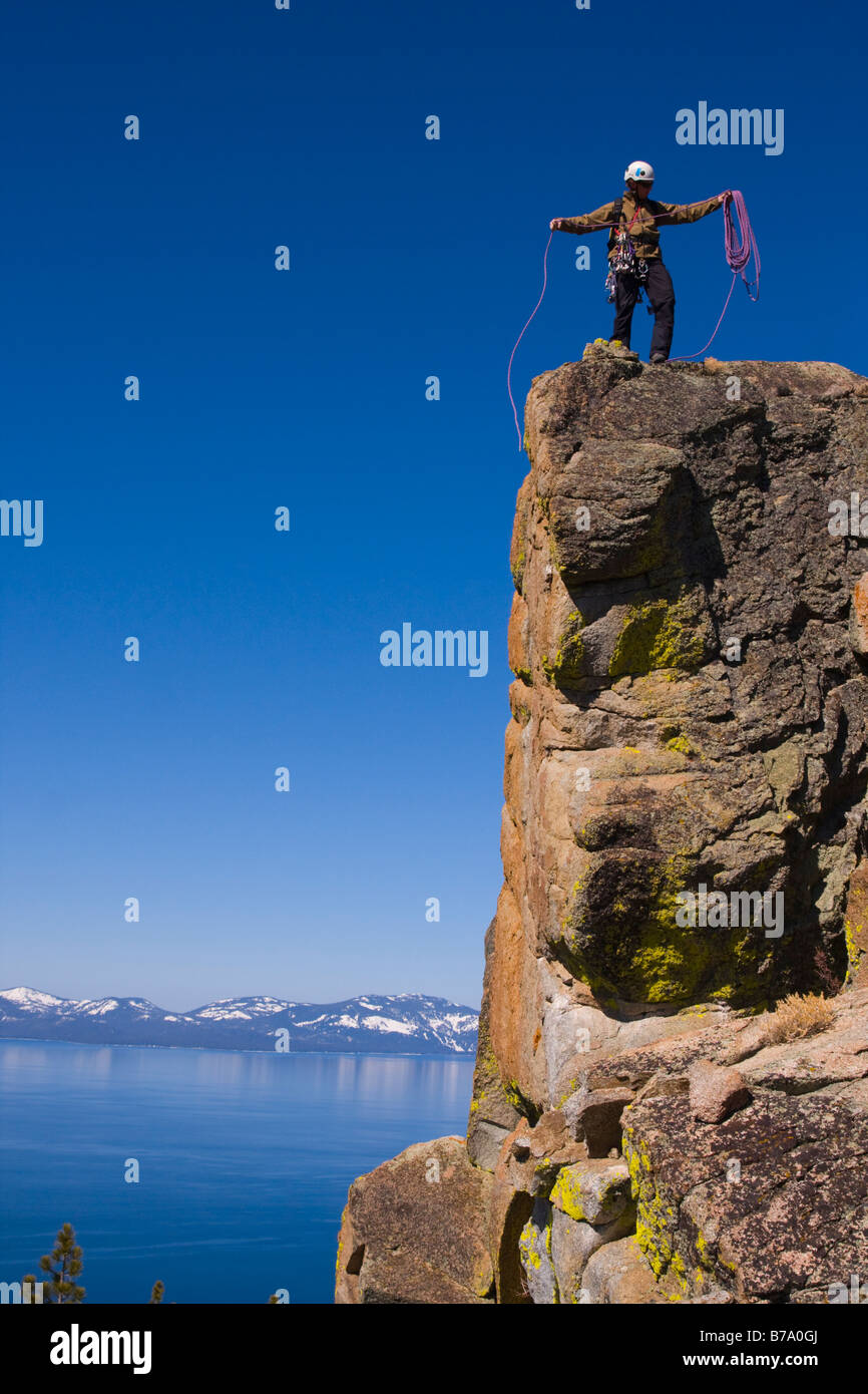 Un comité permanent de l'alpiniste au sommet d'une falaise au-dessus du lac Tahoe dans le Nevada enrouler sa corde Banque D'Images
