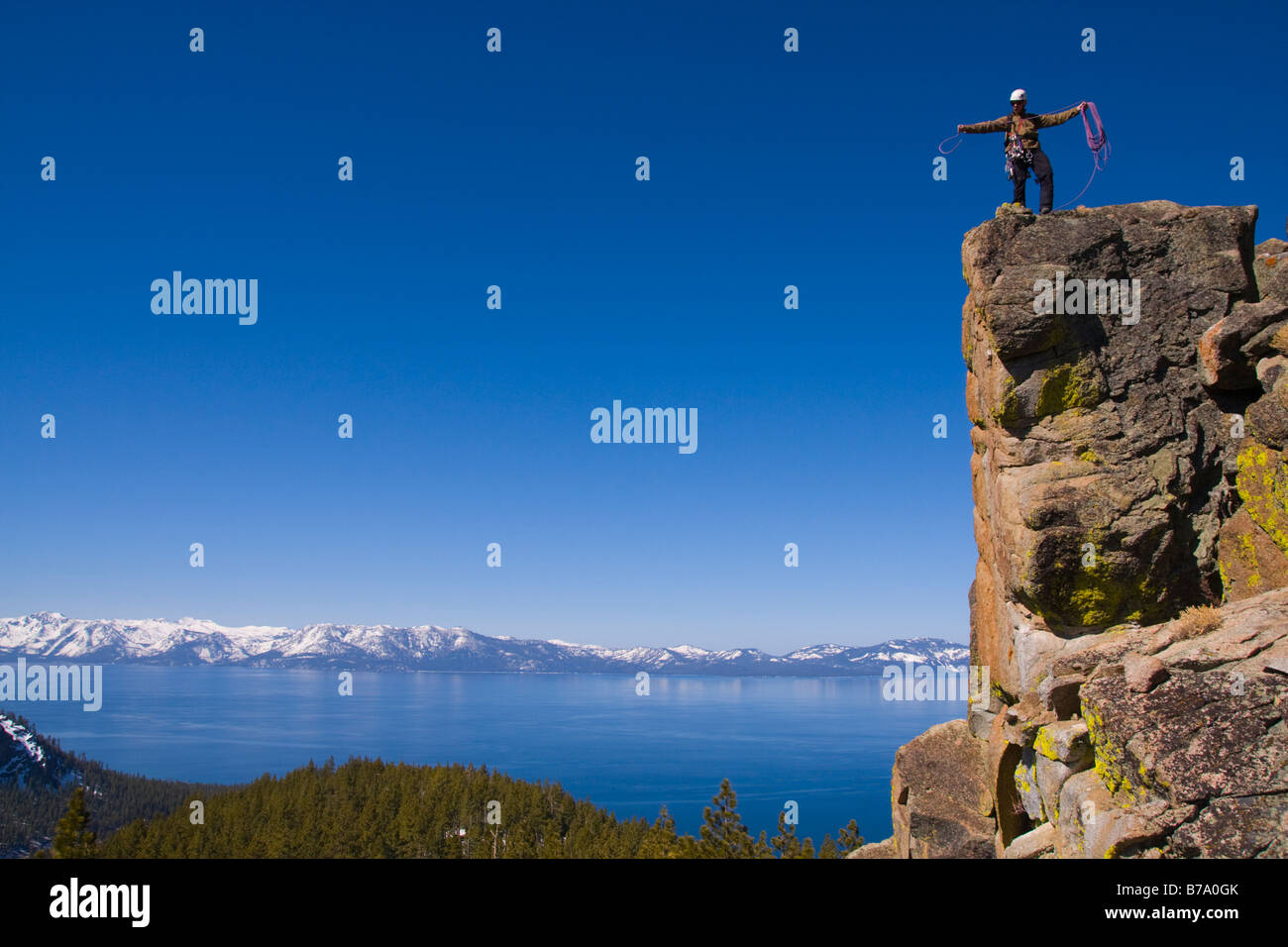 Un comité permanent de l'alpiniste au sommet d'une falaise au-dessus du lac Tahoe dans le Nevada enrouler sa corde Banque D'Images