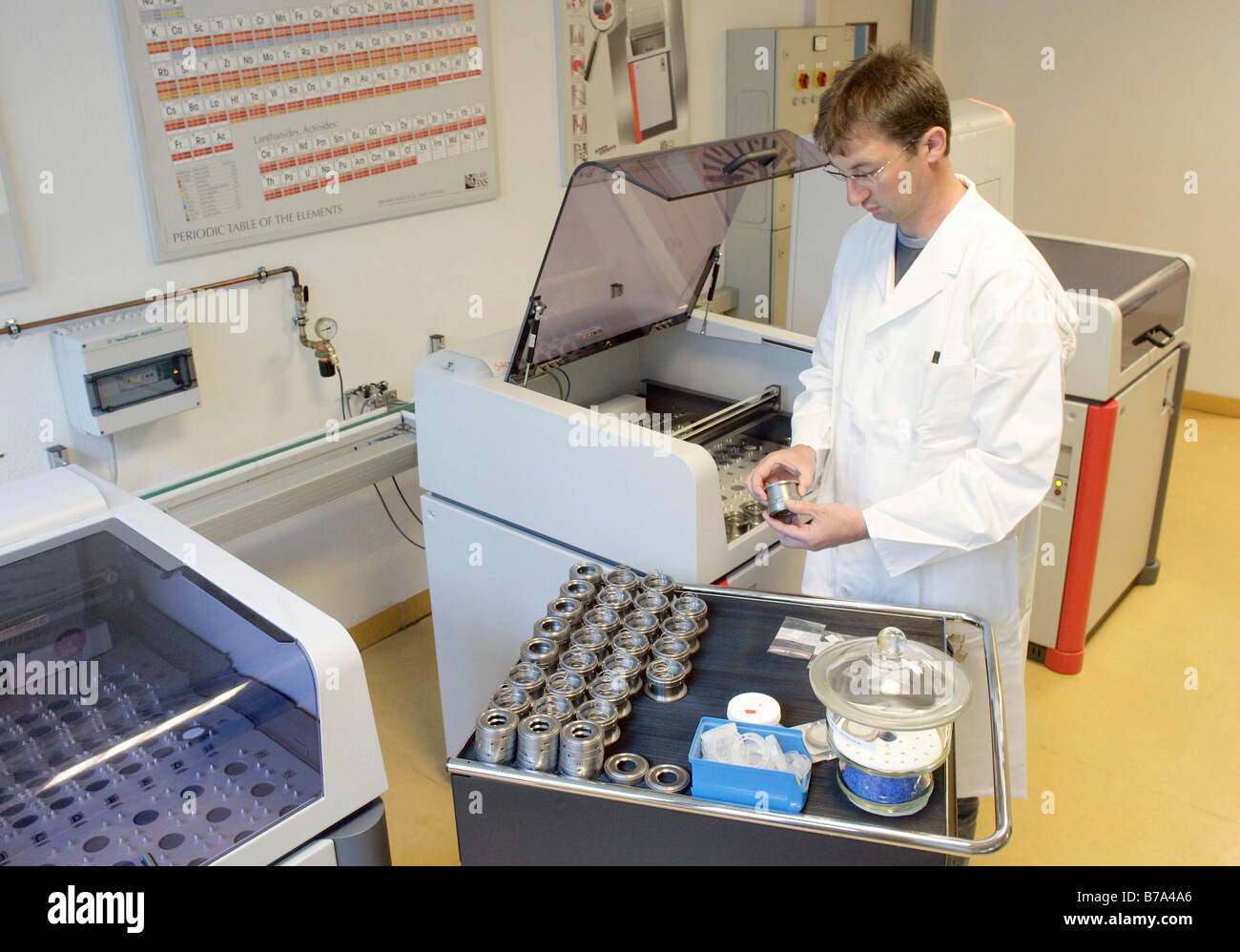 Membre du personnel du contrôle de la qualité, à l'aide d'une machine à fluorescence de rayons X dans le laboratoire de la cimenterie de Schwarzenfeld Banque D'Images