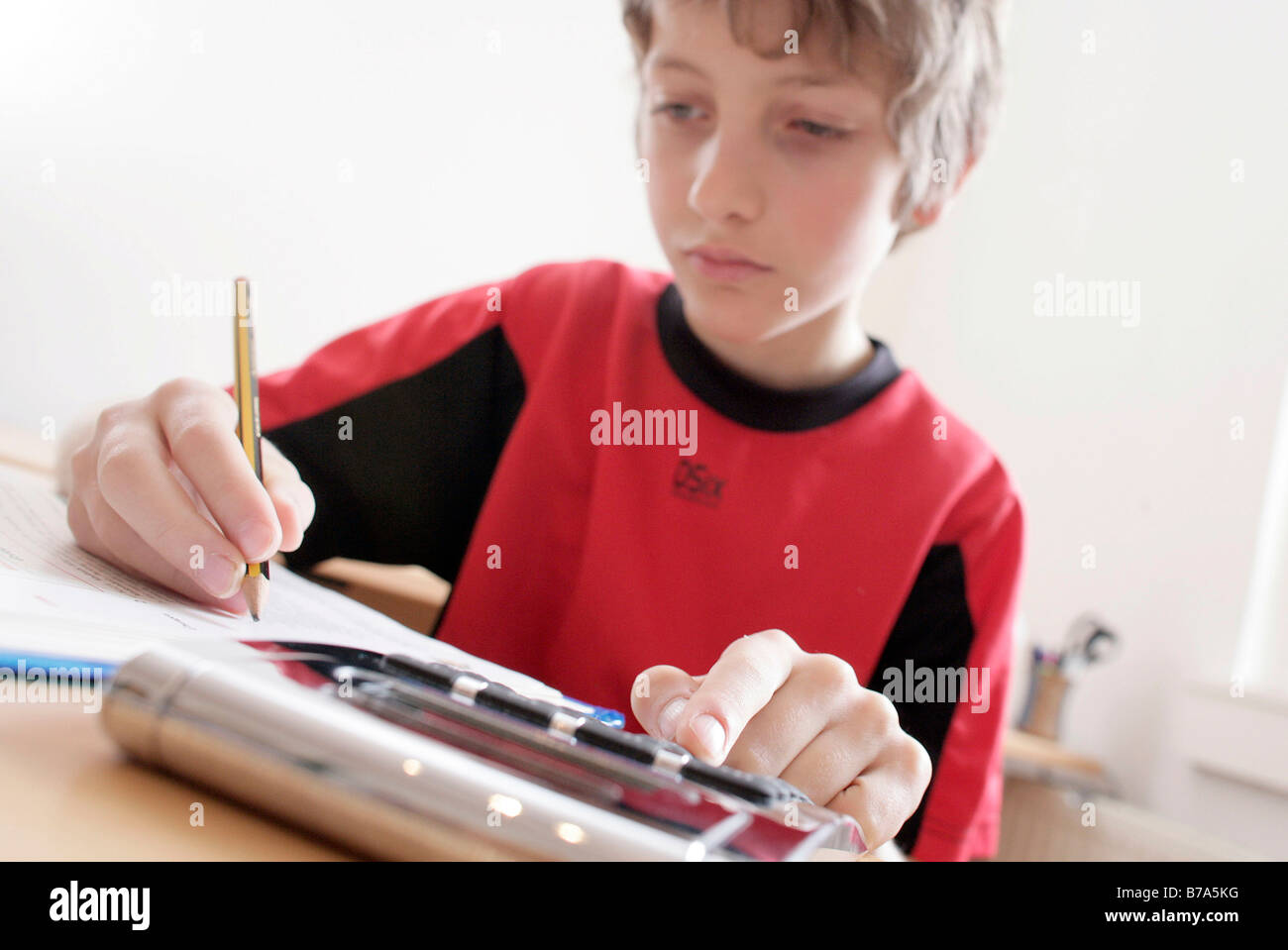 Jeune garçon de 10 ans, faire ses devoirs avec une calculatrice Banque D'Images