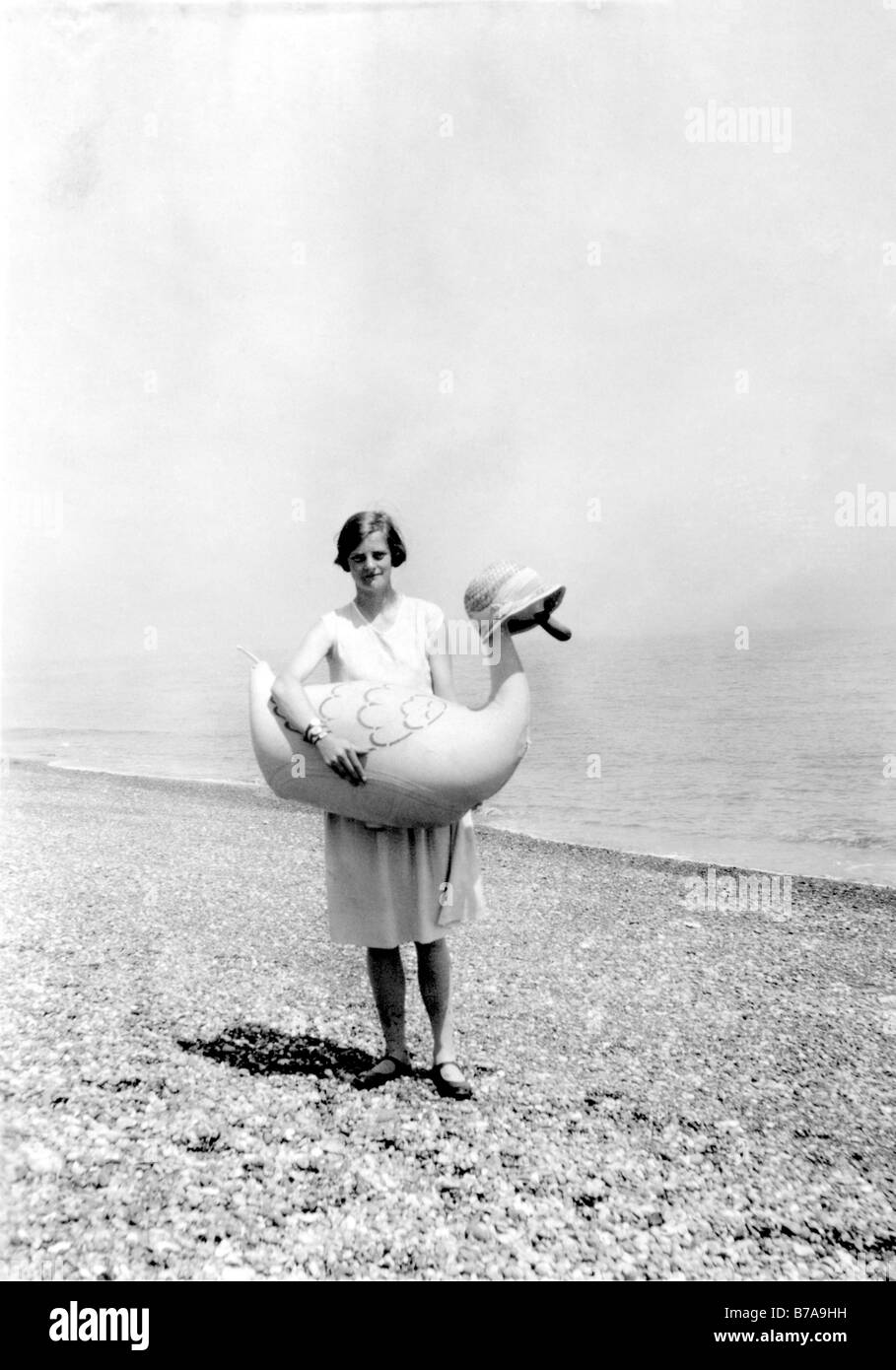 Photo historique, femme à la plage avec le canard en caoutchouc, ca. 1930 Banque D'Images