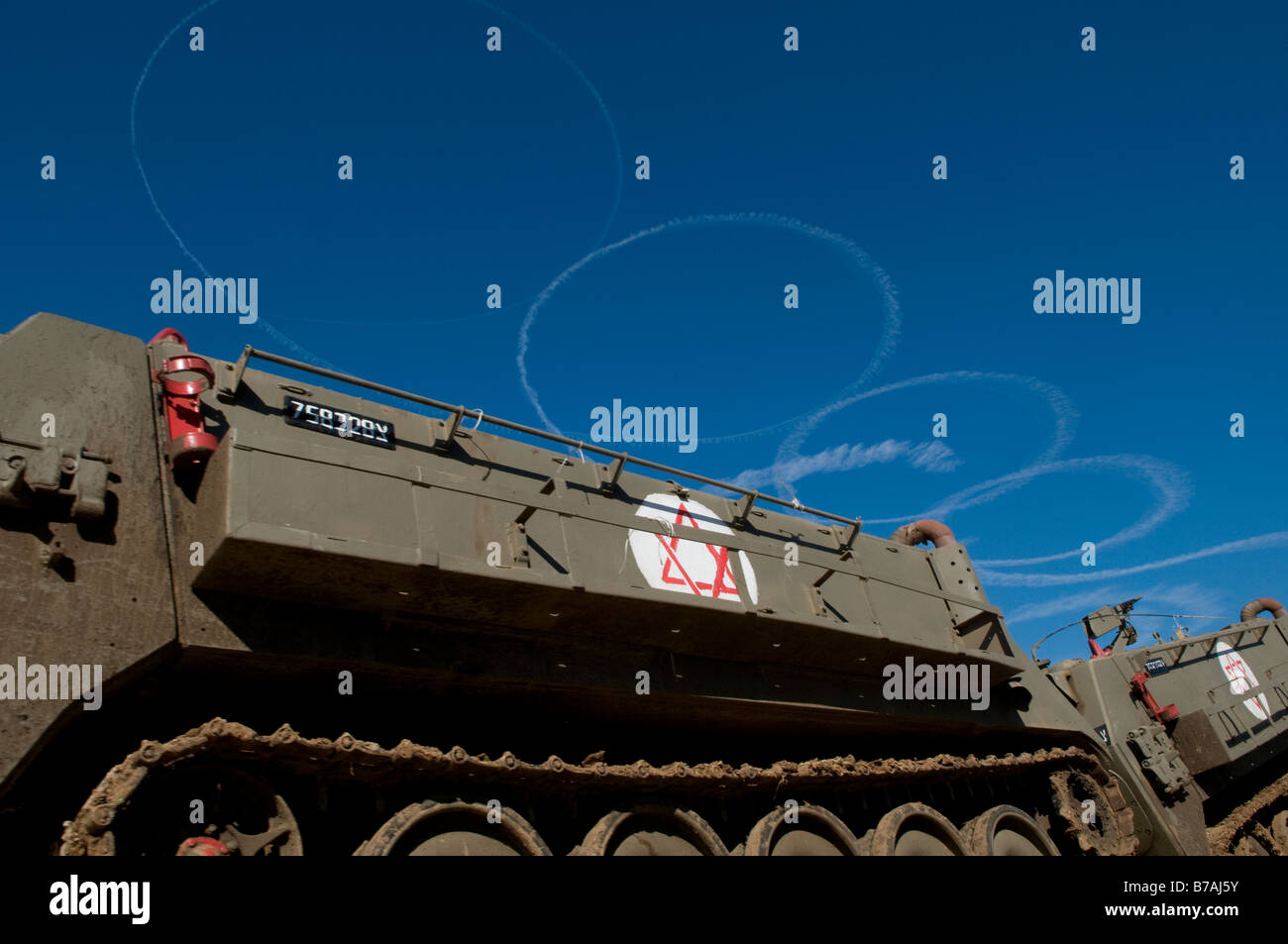 La fumée des avions israéliens laissent des traces dans le ciel avec APC blindés à la frontière israélienne avec la bande de Gaza Banque D'Images