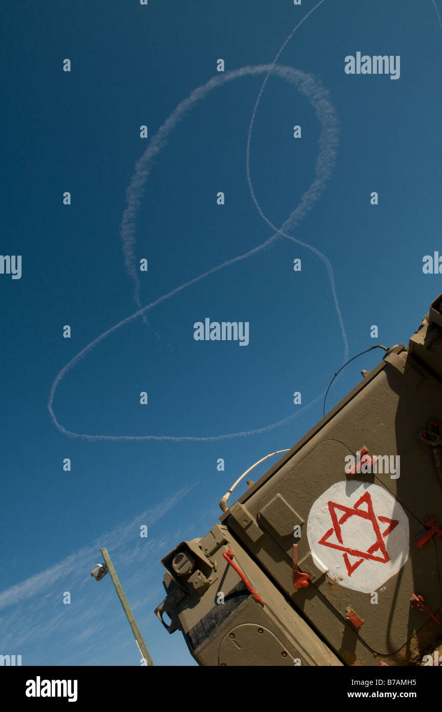 La fumée des avions israéliens laissent des traces dans le ciel avec APC blindés à la frontière israélienne avec la bande de Gaza Banque D'Images
