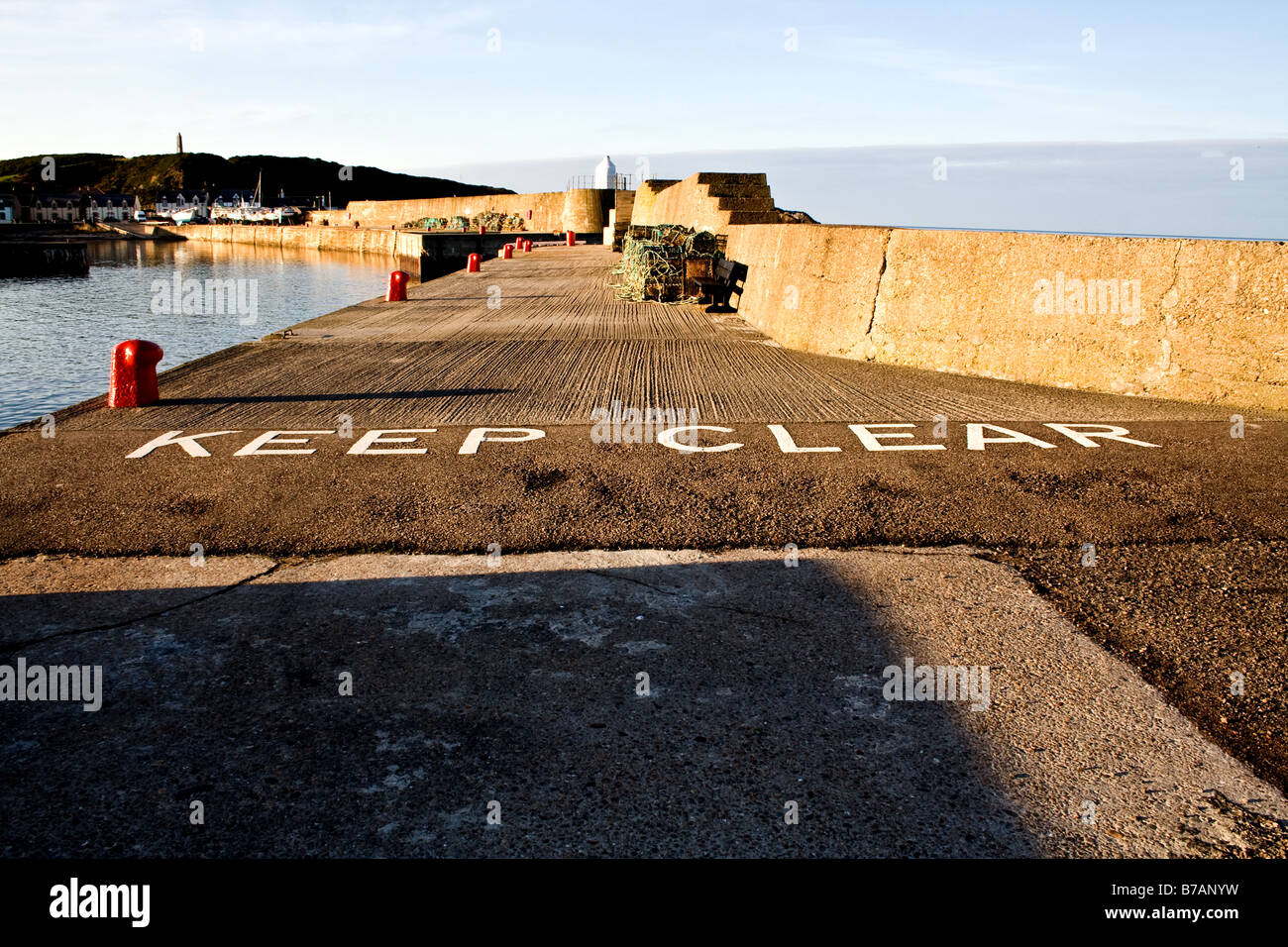 "Rester à l'écart" peint sur la jetée de pierre Findochty, l'Écosse sur le Moray Firth Banque D'Images