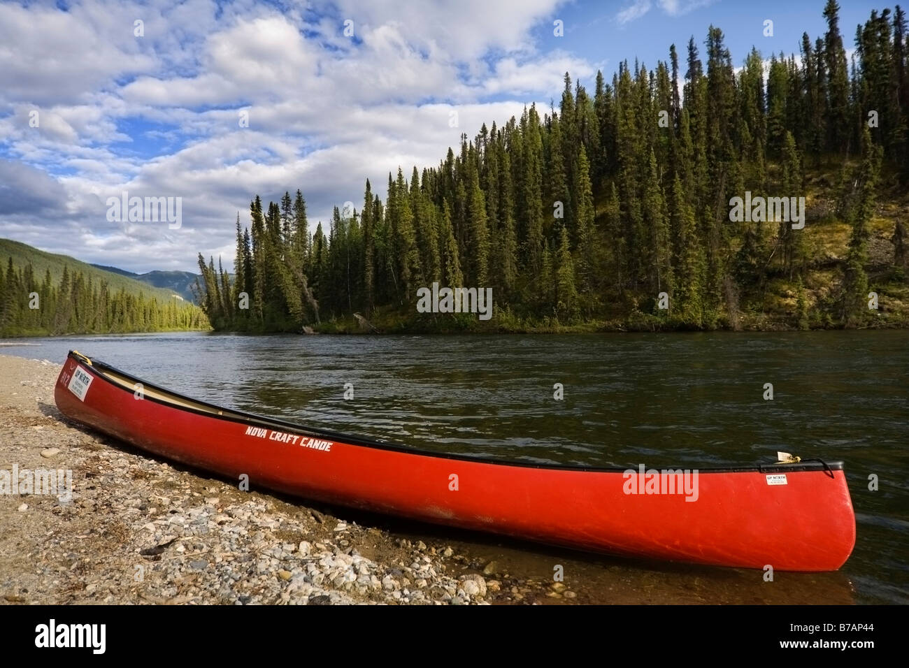 Red canoe sur les rives de la rivière Big Salmon, Territoire du Yukon, Canada, Amérique du Nord Banque D'Images