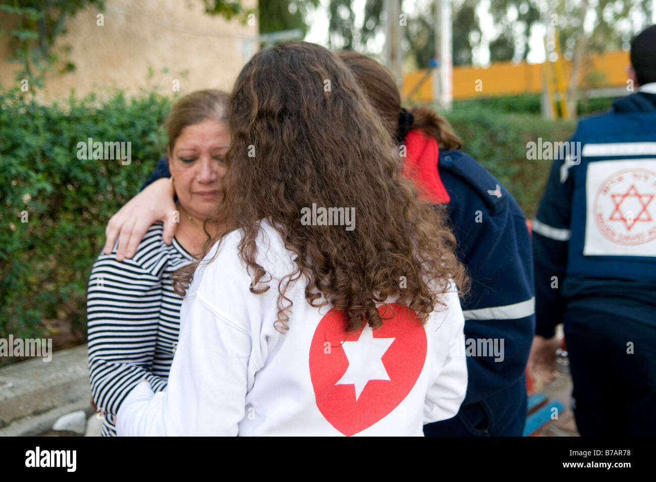 Un paramédic du service d'urgence de Magen David Adom hante un civil israélien en état de choc après l'attaque à la roquette du Qassam palestinien à Sderot, dans le sud d'Israël Banque D'Images