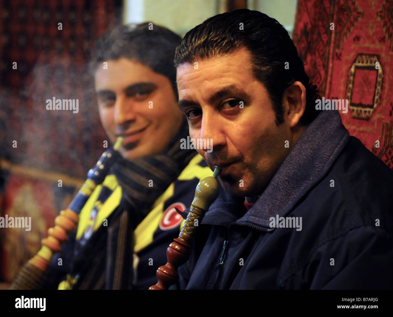 Deux hommes turcs s'asseoir ensemble fumeur pipe a eau (traditionnel/Shisha Nargile) dans une cour à Eminonu, Istanbul. Banque D'Images