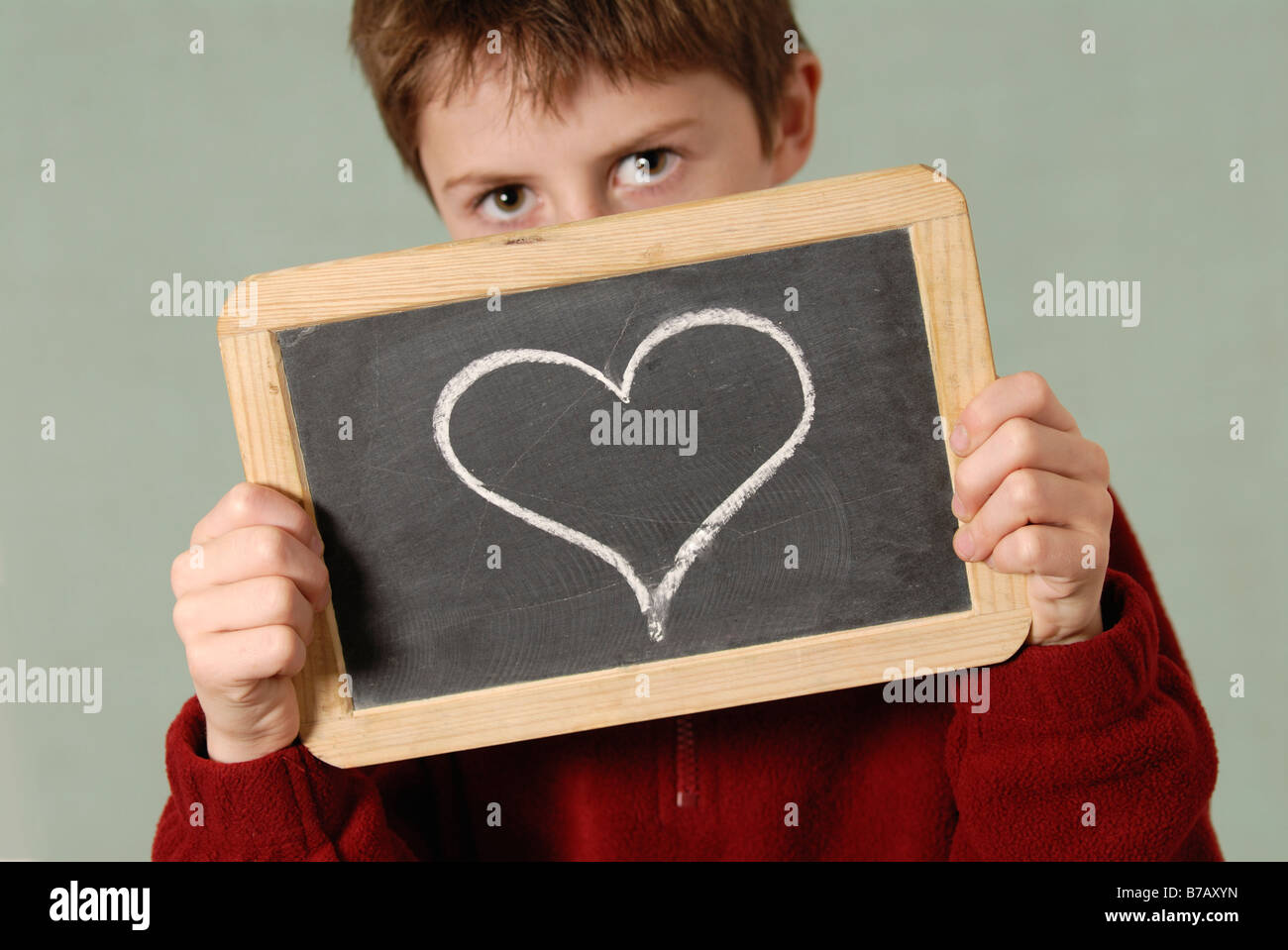Boy Holding Tableau avec coeur dessiné dessus Banque D'Images