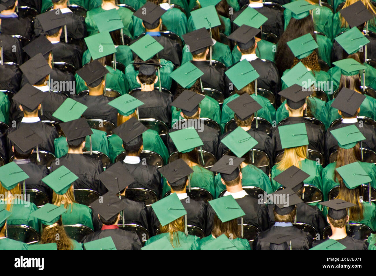 Les élèves du secondaire en majuscules et des blouses d'impatients de continuer d'après l'obtention du diplôme. Banque D'Images