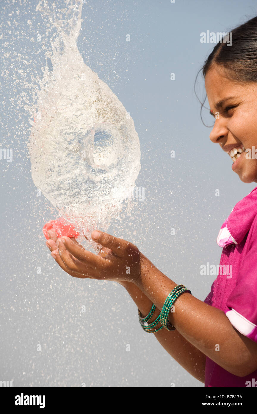 Indian girl attraper un ballon d'eau en rafale. L'Andhra Pradesh. L'Inde Banque D'Images