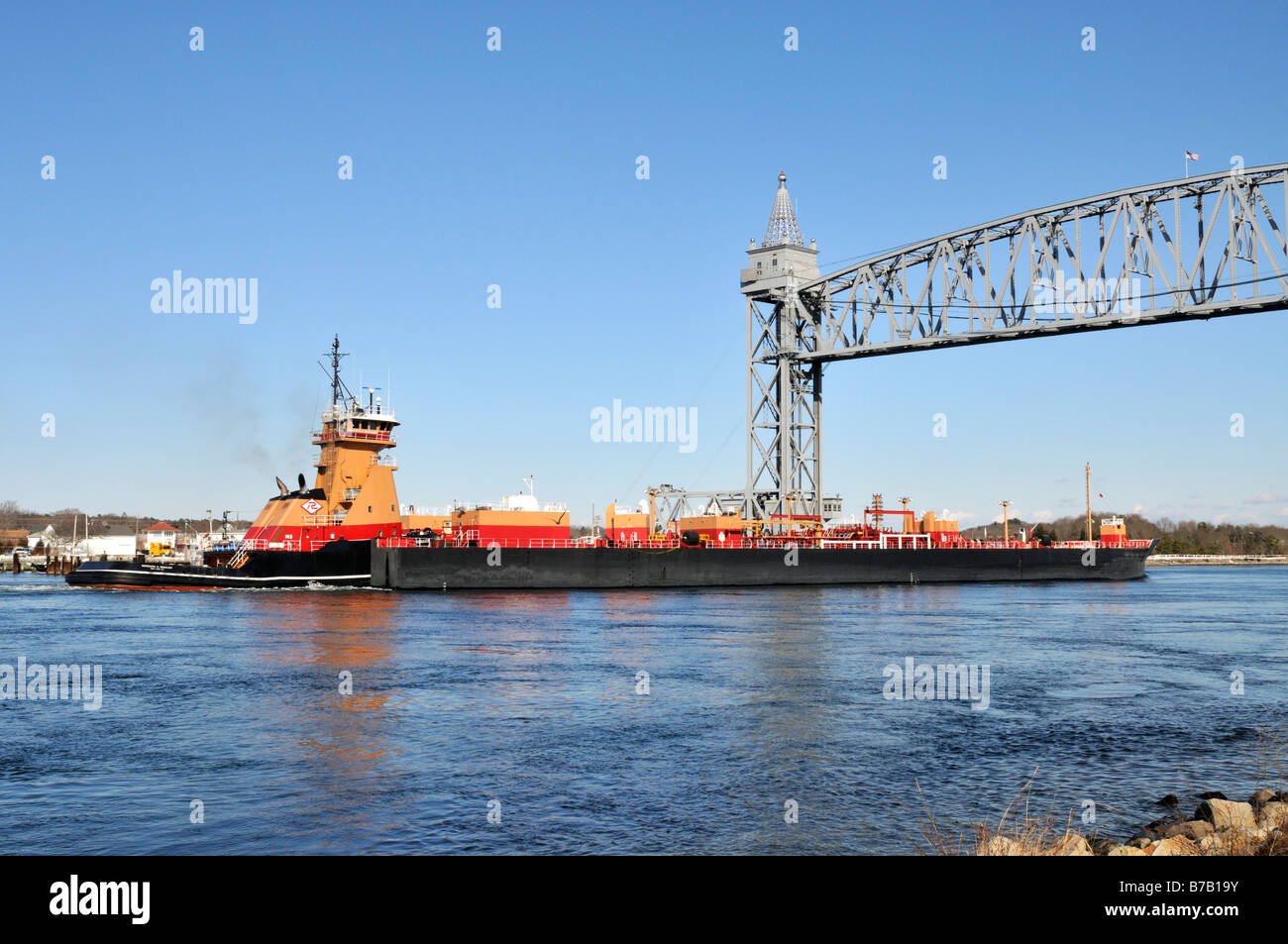 Tugboat pushing barges d'huile combustible double coque par Cape Cod Canal sous pont de chemin de fer, USA Banque D'Images